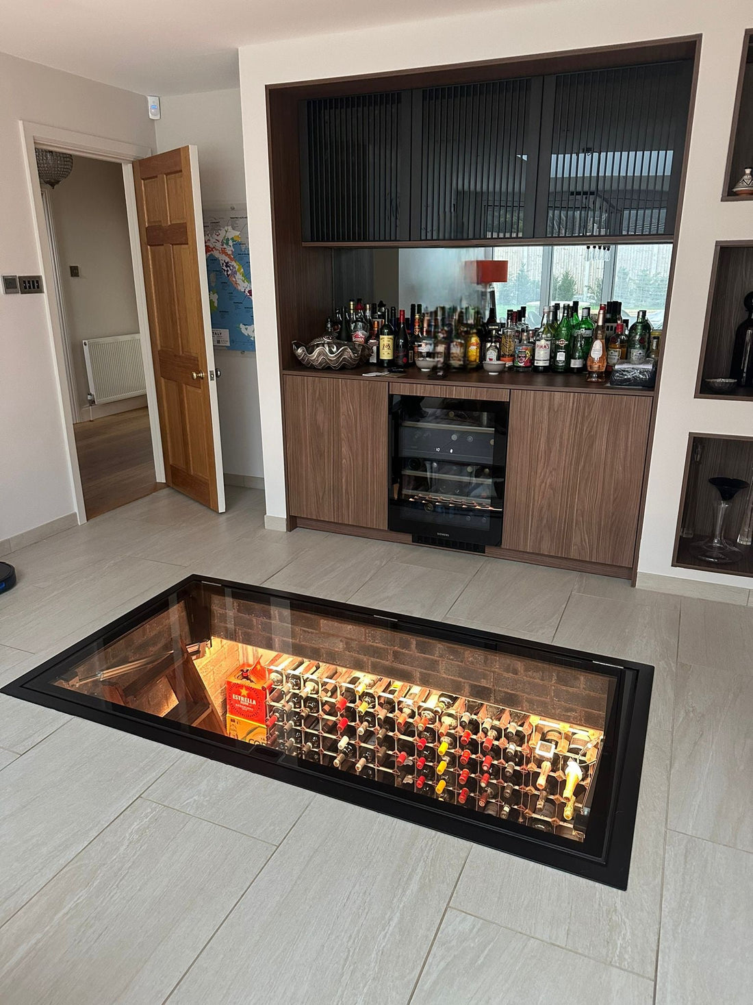 Electric hinged glass wine cellar door by Glass Floor Systems Ltd for large wine cellar access.