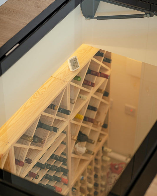 "Custom hinged wine cellar door with electric option and round design, installed in a UK home, showcasing walk-on safety glass from Glass Floor Systems
