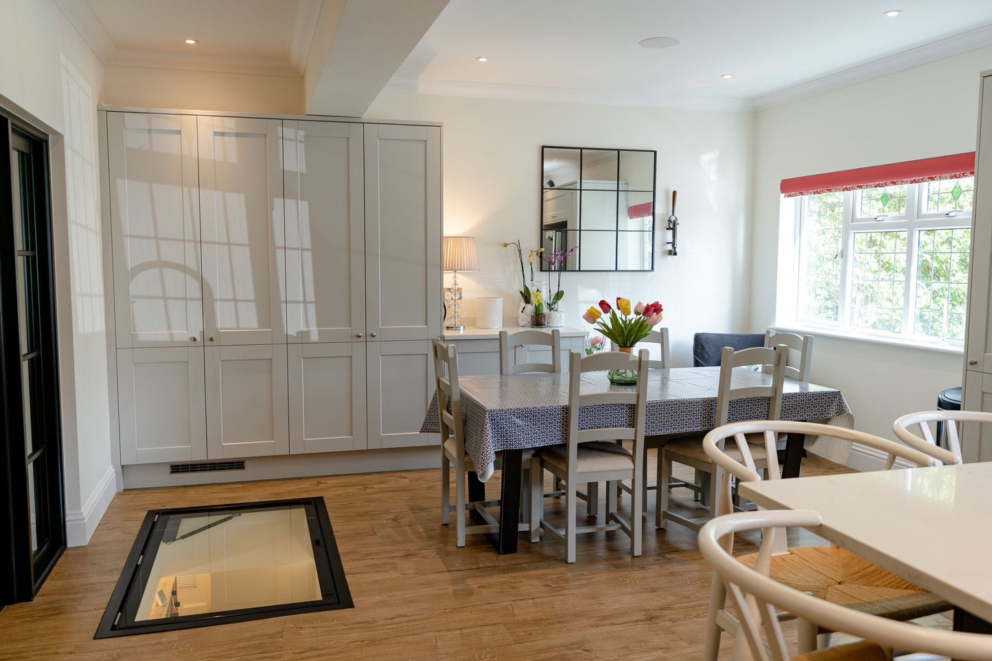 Modern kitchen with white cabinets, a dining table, and chairs.