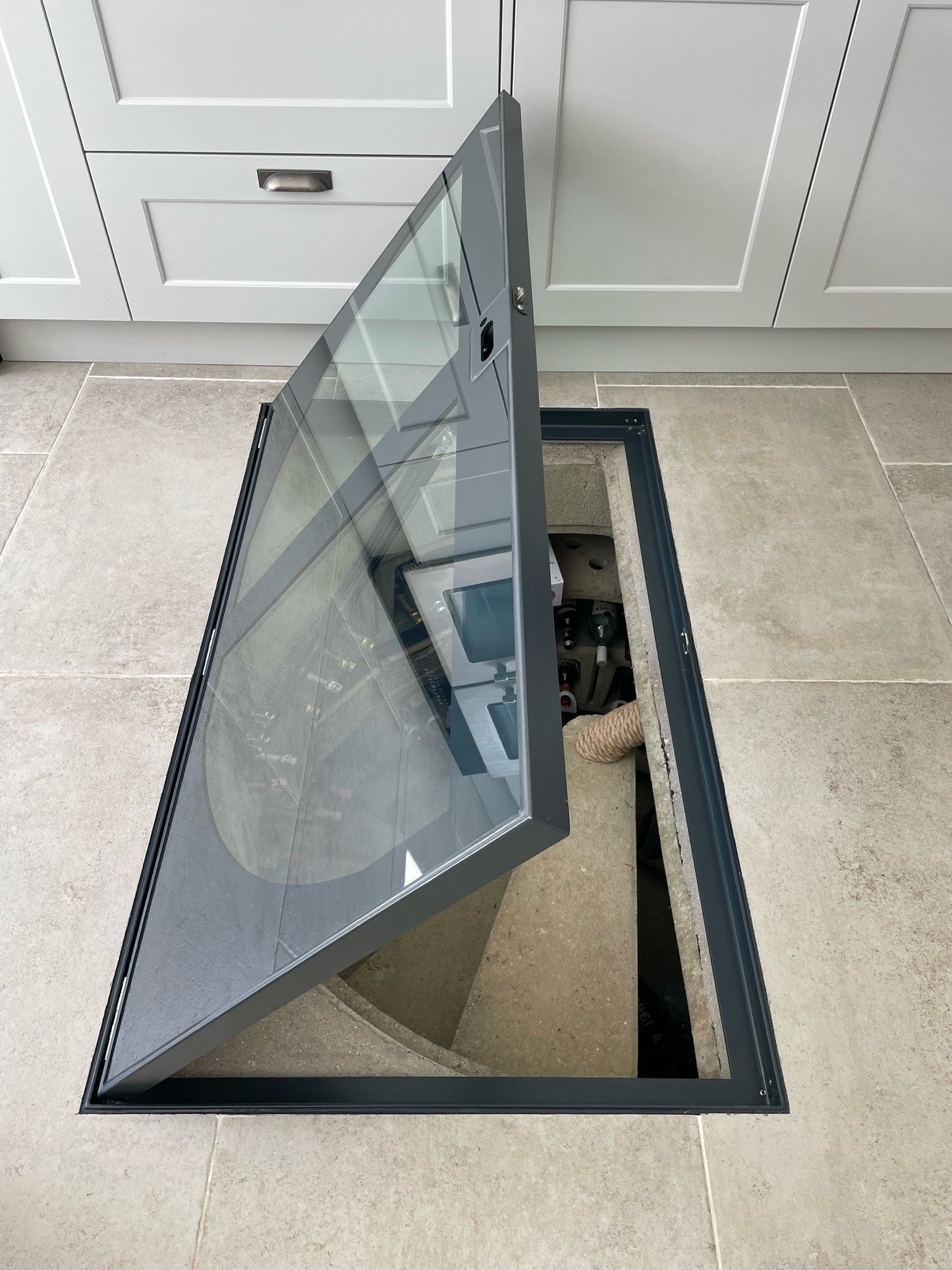 A view from into a spiral wine cellar down at the glass lid, showing how the walk-on glass allows natural light into the space.