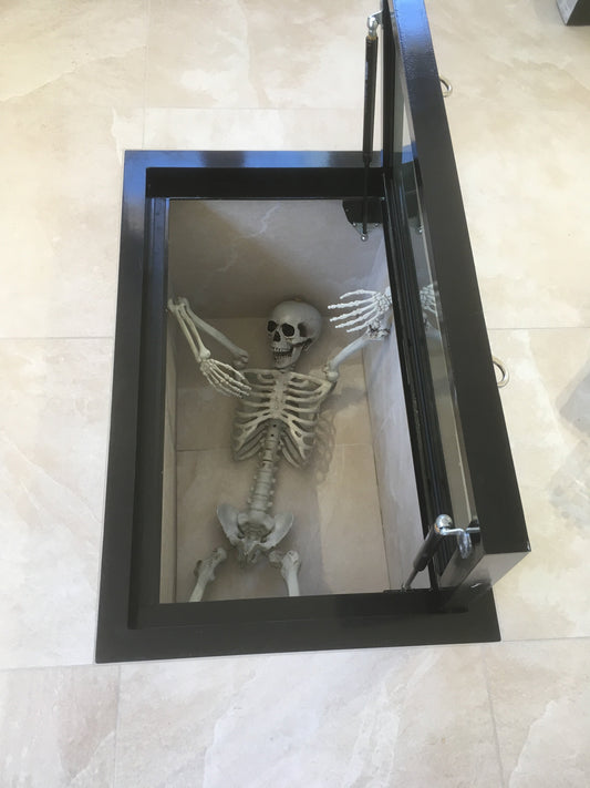  A walk-on glass floor hatch in a living room, acting as a display Halloween themes basement below.