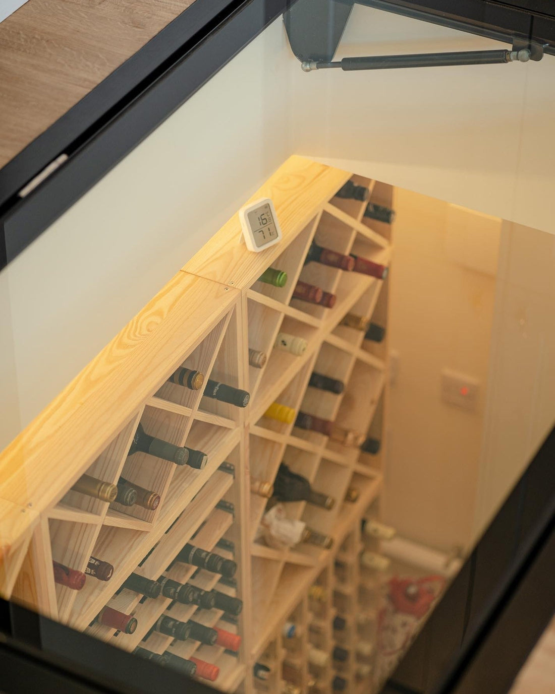 "Custom hinged wine cellar door with electric option and round design, installed in a UK home, showcasing walk-on safety glass from Glass Floor Systems