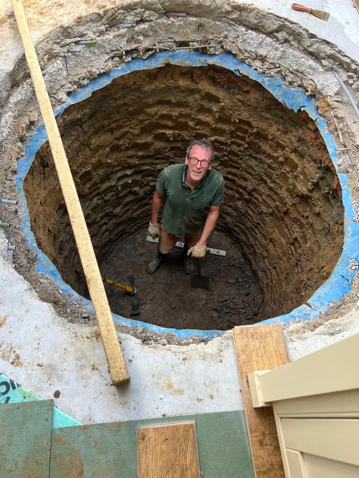 man digging out hole for spiral wine cellar DIY project