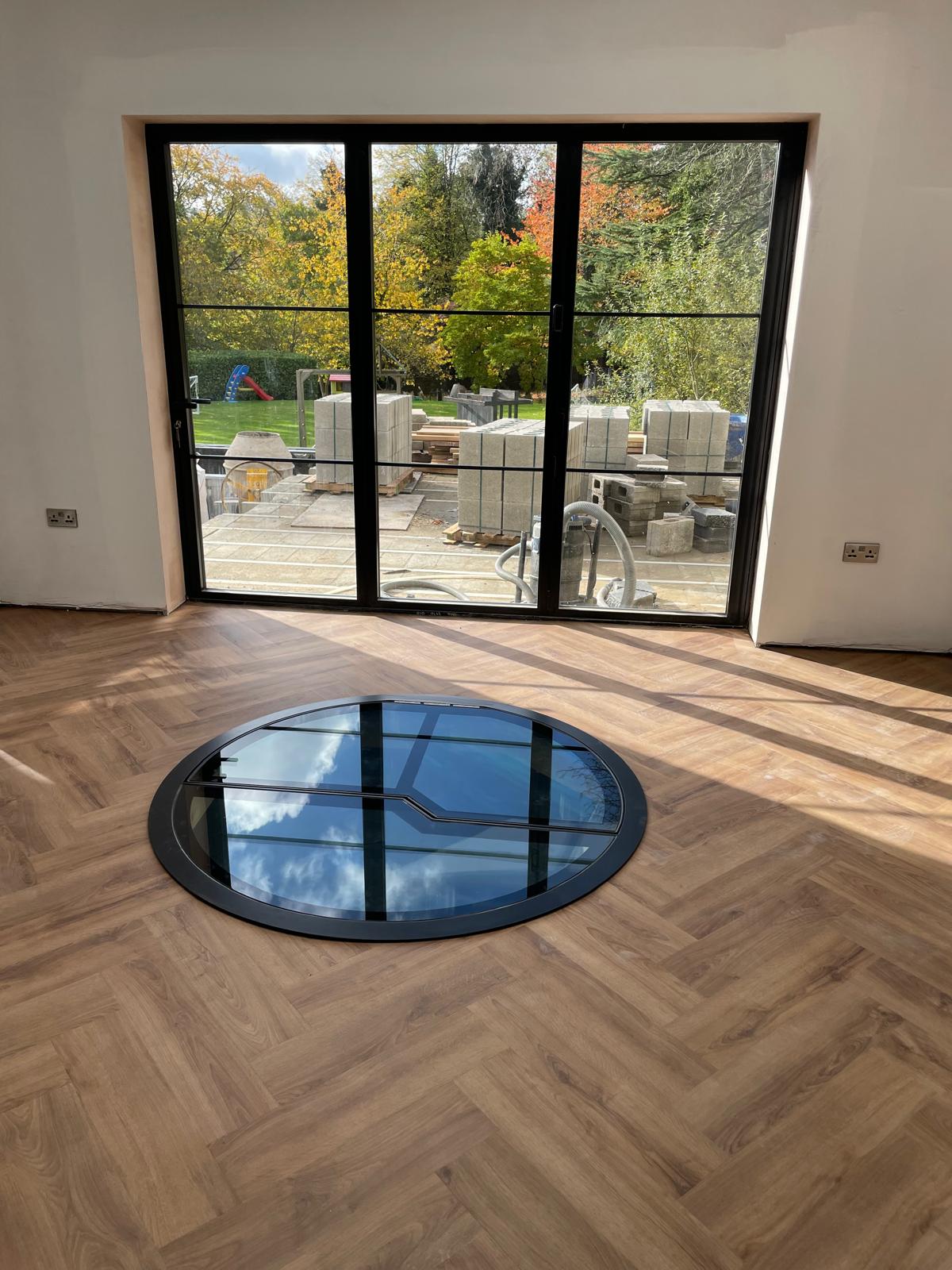 remote controlled electric automated glass door over spiral wine cellar hatch
